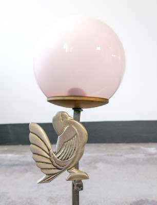 Lampada da comodino, da tavolo, con scultura di bambina e uccellino in metallo, lume sferico in vetro rosato. Primo Novecento