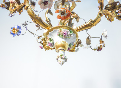 Lampadario liberty a sei lumi in ottone e ceramica policroma, decorazione floreale. Italia, Primo Novecento