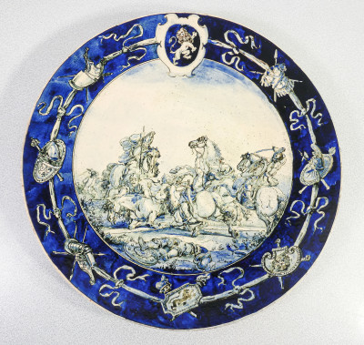 Piatto commemorativo in maiolica dipinta in monocromia blu di cobalto, raffigurante una Battaglia. Firmato P. Villa. Area savonese, 1886