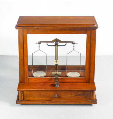 Bilancia da farmacia di precisione, teca in legno, con meccanismo di sollevamento dei piatti, cassetto e pesini. Italia, Fine Ottocento Primo Novecento