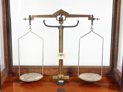 Bilancia da farmacia di precisione, teca in legno, con meccanismo di sollevamento dei piatti, cassetto e pesini. Italia, Fine Ottocento Primo Novecento