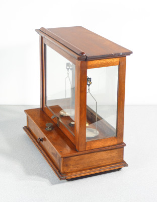 Bilancia da farmacia di precisione, teca in legno, con meccanismo di sollevamento dei piatti, cassetto e pesini. Italia, Fine Ottocento Primo Novecento