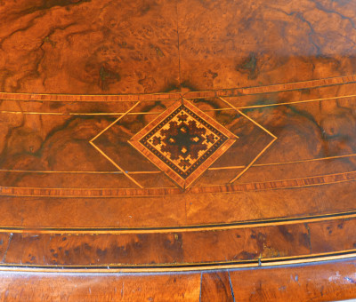 Tavolo vittoriano in legno e radica, con piano ovale intarsiato e filettato. Inghilterra, 1800
