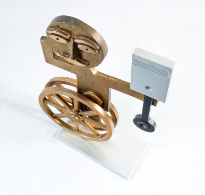 Scultura in bronzo di Mario MOLINARI. Figura con ruote e pistone. Italia, Anni 60/70