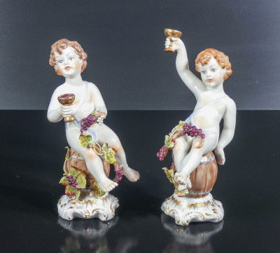 Coppia di sculture in porcellana dipinta a mano Putti Baccanti, man. di Capodimonte. Italia, Metà Novecento