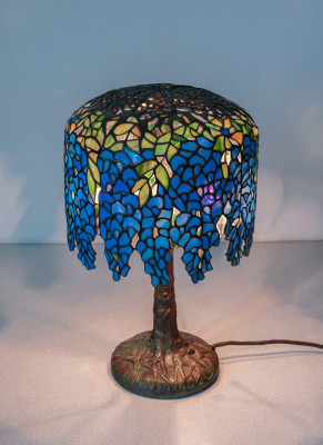 Lampada Tiffany, motivo Wisteria, tre lumi con accensione a catenella, in vetro piombato e bronzo. Novecento