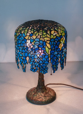 Lampada Tiffany, motivo Wisteria, tre lumi con accensione a catenella, in vetro piombato e bronzo. Novecento