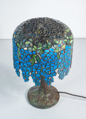 Lampada Tiffany, motivo Wisteria, tre lumi con accensione a catenella, in vetro piombato e bronzo. Novecento