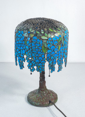Lampada Tiffany, motivo Wisteria, tre lumi con accensione a catenella, in vetro piombato e bronzo. Novecento