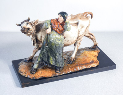 Scultura in ceramica dipinta e smaltata, firmata Guido CACCIAPUOTI. Contadina con mucca. Italia, Anni 30/40