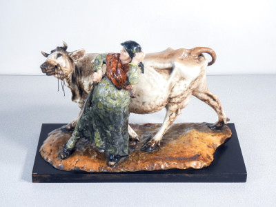 Scultura in ceramica dipinta e smaltata, firmata Guido CACCIAPUOTI. Contadina con mucca. Italia, Anni 30/40