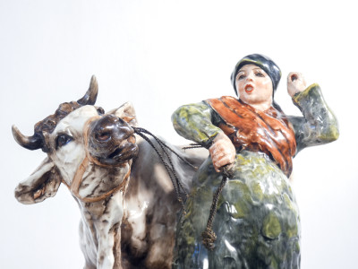 Scultura in ceramica dipinta e smaltata, firmata Guido CACCIAPUOTI. Contadina con mucca. Italia, Anni 30/40