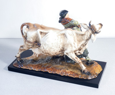 Scultura in ceramica dipinta e smaltata, firmata Guido CACCIAPUOTI. Contadina con mucca. Italia, Anni 30/40