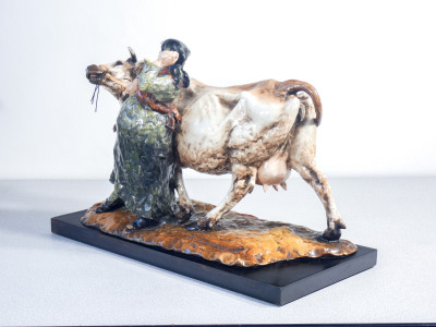 Scultura in ceramica dipinta e smaltata, firmata Guido CACCIAPUOTI. Contadina con mucca. Italia, Anni 30/40