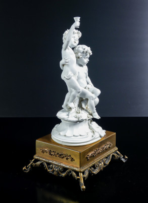 Scultura in porcellana biscuit a firma BENACCHIO, della manifattura TRIADE, Putti baccanti. Bassano Italia, Anni 70