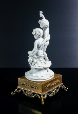 Scultura in porcellana biscuit a firma BENACCHIO, della manifattura TRIADE, Putti baccanti. Bassano Italia, Anni 70